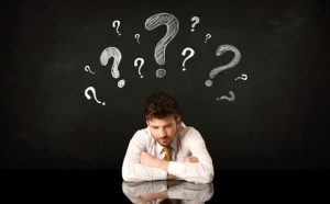 Man Sitting Under Question Marks