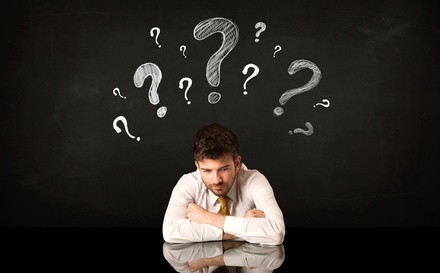 Man Sitting Under Question Marks